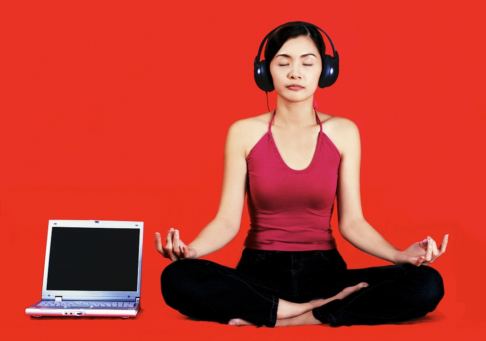 “Woman listening to audio session with headphones at laptop”