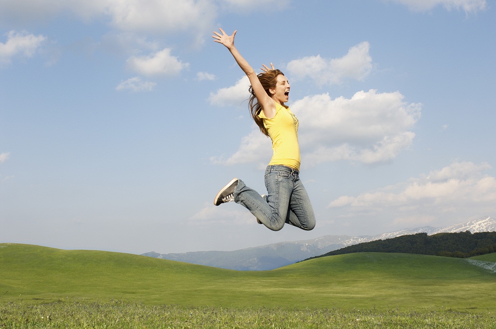 “Woman celebrating outdoors with arms raised in joy”