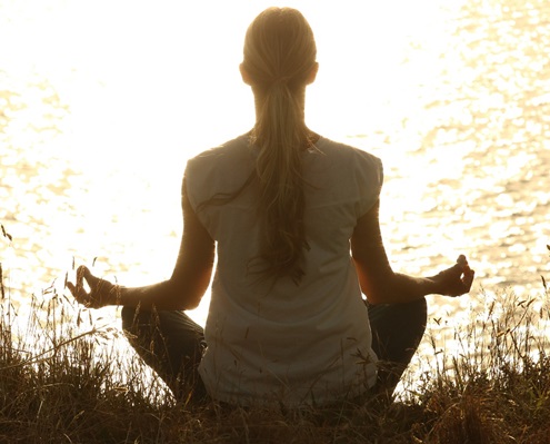 Grounded person practicing root chakra yoga in nature